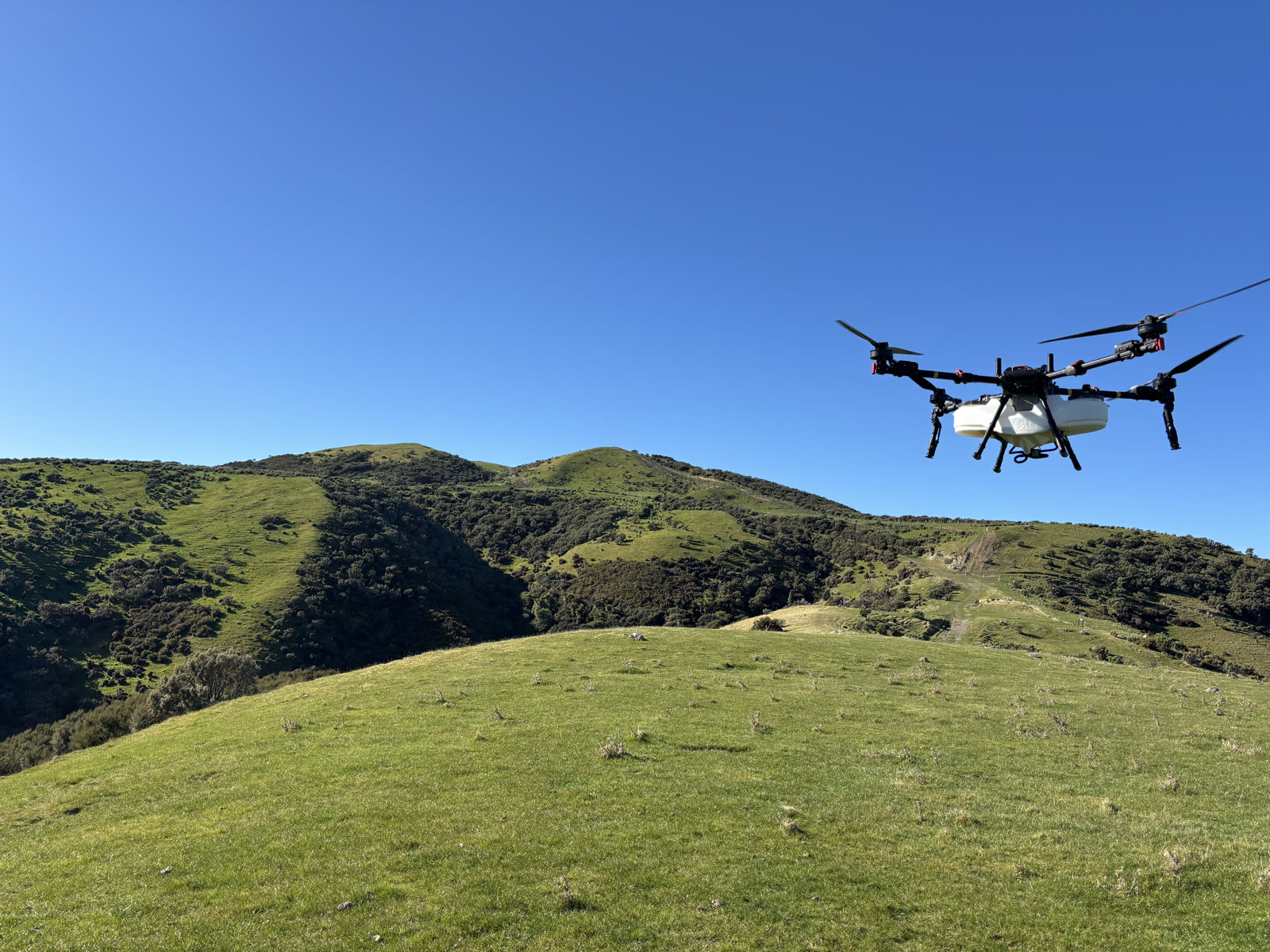 KC Drone Solutions XAG agricultural drone in flight over the Wairarapa coast