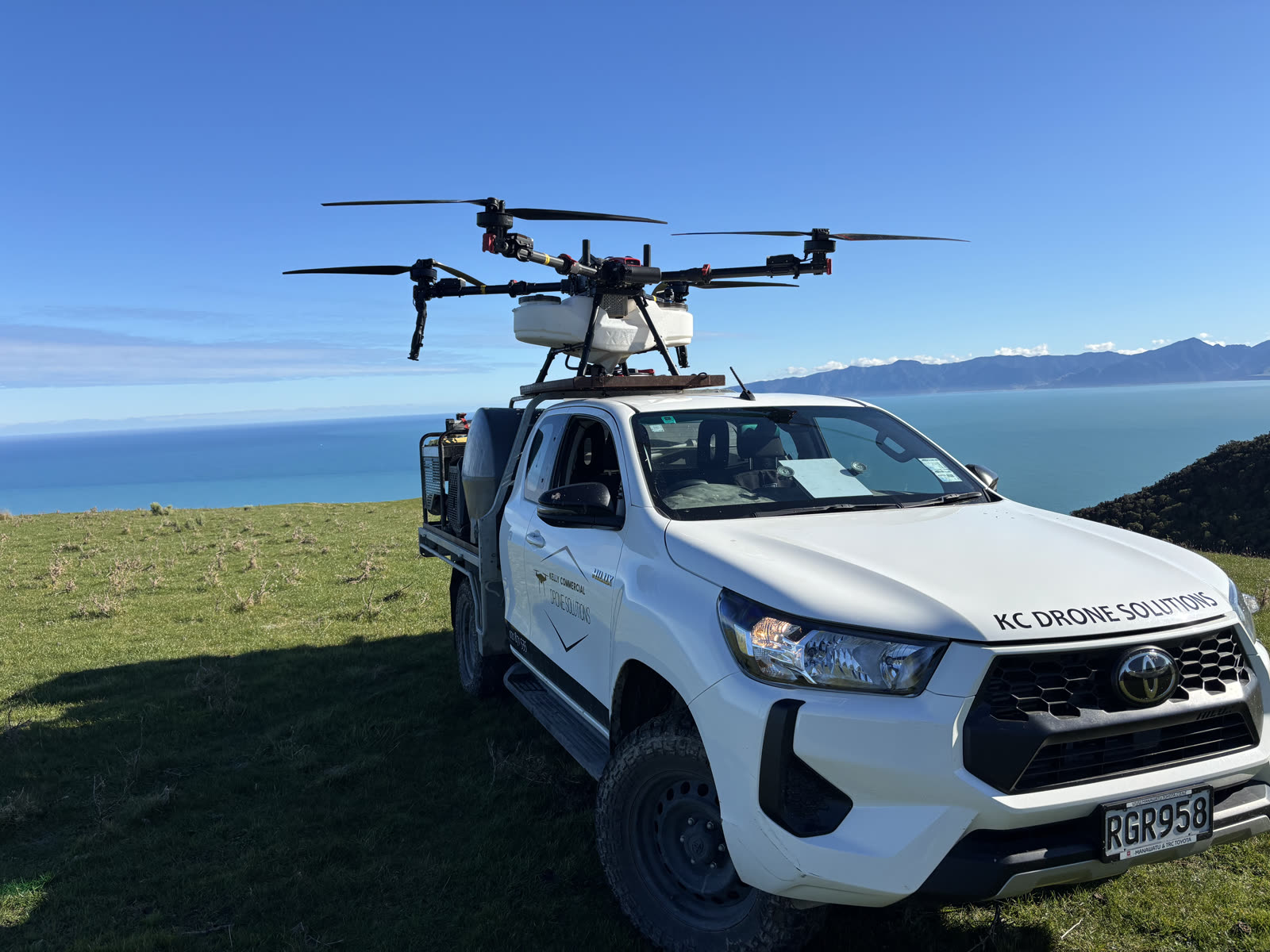 KC Drone Solutions XAG agricultural drone mounted on the service vehicle overlooking the Wairarapa coast
