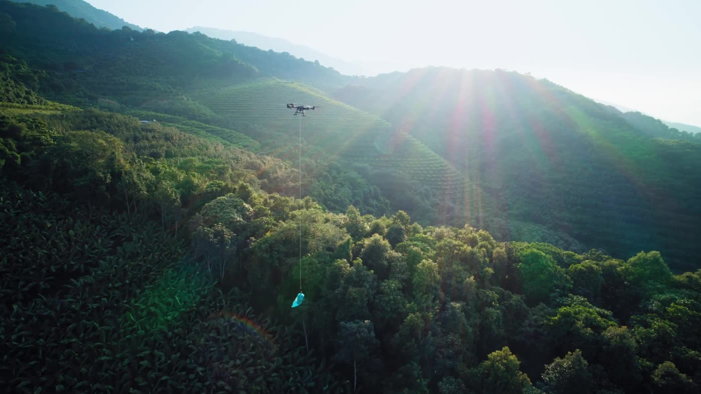 XAG P150 Max lifting a load across steep orchard terrain on the RevoSling line